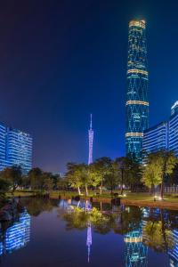 Un rascacielos alto se ilumina por la noche en Four Seasons Hotel Guangzhou, en Guangzhou