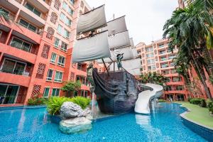 a pool with a pirate ship slide in a building at Sonia residence - SHA Extra Plus in Jomtien Beach