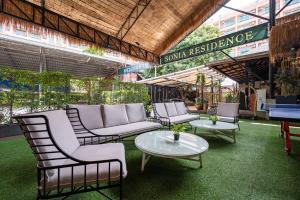 a group of chairs and tables on a patio at Sonia residence - SHA Extra Plus in Jomtien Beach