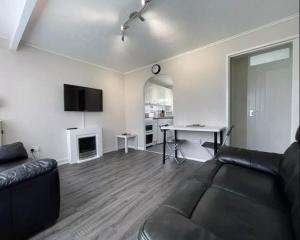 a living room with a black couch and a desk at Chalet hemsby in Great Yarmouth