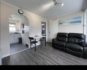 sala de estar con sofá de cuero y mesa en Chalet hemsby en Great Yarmouth