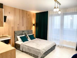 Un dormitorio con una cama con almohadas azules y una ventana en Апартаменты с видом на Лес и Реку, en Barnaul