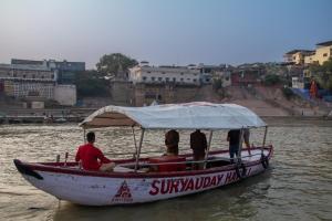 een groep mensen op een boot in het water bij Amritara Suryauday Haveli in Varanasi