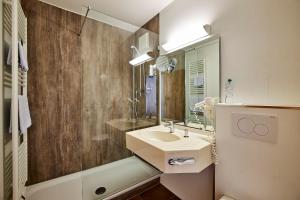 a bathroom with a sink and a mirror at Hotel Schwertfirm in Karlsfeld