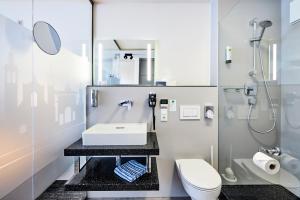 y baño con lavabo y aseo. en Hotel Schwertfirm, en Karlsfeld