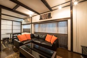 a living room with a leather couch and a table at Rinn Kiyomizu Villa in Kyoto