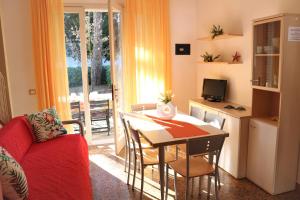 uma sala de estar com uma mesa e uma cozinha em Beautiful villa just few steps from the beach em Bibione