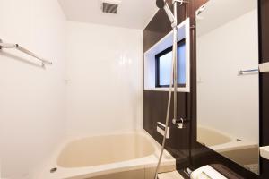 a bathroom with a bath tub and a shower at Rinn Kiyomizu Villa in Kyoto