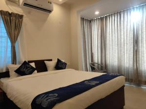 a bedroom with a large bed in front of a window at AMULYA FINE DINE RESIDENCY in Bangalore