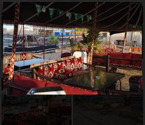 a group of red chairs and a glass table at Royal Tours Permanent Camp in Umm Lujj