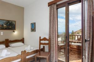 1 dormitorio con 1 cama y balcón en Pension Lucy, en Panormos Rethymno