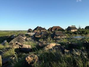 a group of houses in a field with rocks at Slypsteen Guest Farm in Sternham