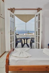 a bedroom with a bed and a table with a view at 180° View to Sea in Vathí