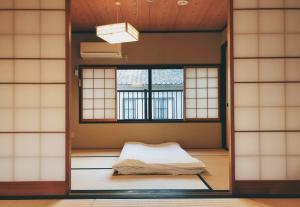 a room with a bed in a room with windows at Kyoto Nijo Guest House HoshiIke villa in Kyoto