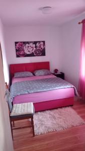 - une chambre avec un grand lit et une tête de lit rose dans l'établissement Holiday home Marija, à Vrlika