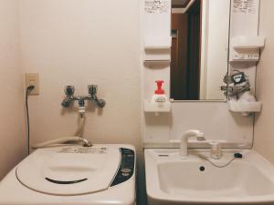 a small bathroom with a toilet and a sink at Kyoto Nijo Guest House HoshiIke villa in Kyoto