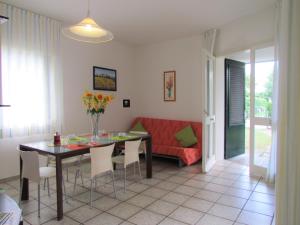 a living room with a dining room table and a couch at The perfect family retreat-Beahost in Bibione +15 photos