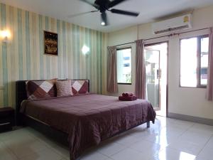 a bedroom with a bed and a ceiling fan at Living Room Guesthouse & Cafe Bar in Karon Beach