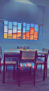 a table and two chairs and a table and windows at سما العلا للشقق المفروشة in AlUla