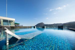 別府的住宿－AMANEK Beppu YULAｰRE，一个带椅子的游泳池
