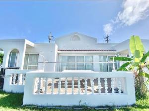 una casa blanca con una valla blanca delante de ella en Villa CocoNatu - KOHAMA - en Kohama