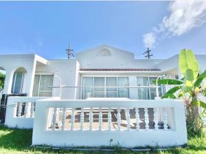 a white house with a white fence in front of it at Villa CocoNatu - KOHAMA - in Kohama