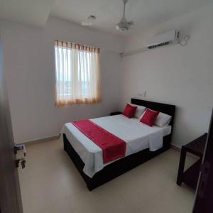 um quarto com uma cama grande e almofadas vermelhas em 3 Bedroom Apartment in close proximity to Beach em Colombo