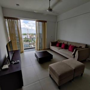 uma sala de estar com um sofá e uma mesa em Modern apartment in close proximity to the Beach em Colombo