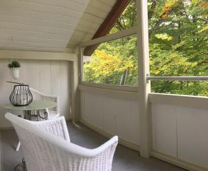 una veranda schermata con tavolo, sedie e finestra di B3 Apartment a Gsteigwiler