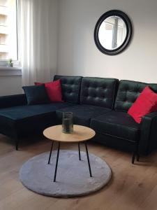 a living room with a black couch and a table at Apartament Rodzinny in Kłodzko