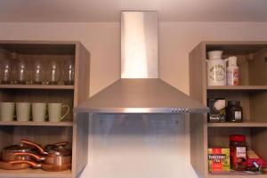 a kitchen with a hood over a white refrigerator at LiveStay-Modern Apartment Minutes Away From Heathrow in Slough