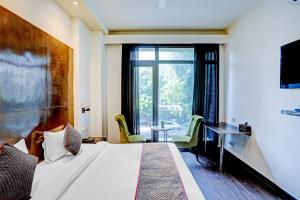 a hotel room with a bed and a large window at The Orion - Greater Kailash in New Delhi