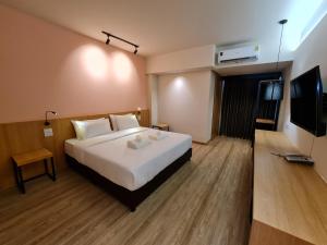 a hotel room with a bed and a flat screen tv at The Neuf@Ratchada in Bangkok