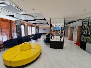 a lobby with a yellow table and chairs at The Neuf@Ratchada in Bangkok
