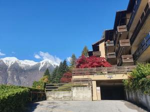 a building with a garage with mountains in the background at 026 Bilocale con caminetto, Giustino in Giustino