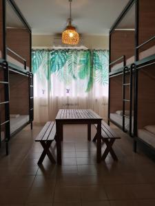 Habitación con mesa, bancos y literas. en Akinabalu Youth Hostel, en Kota Kinabalu