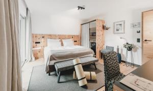 sypialnia z dużym łóżkiem i biurkiem w obiekcie Hotel & Appartements Tiroler Buam w Saalbach Hinterglemm