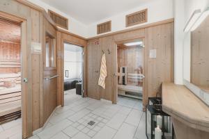 łazienka z drewnianymi ścianami i dużymi drzwiami w obiekcie Hotel & Appartements Tiroler Buam w Saalbach Hinterglemm