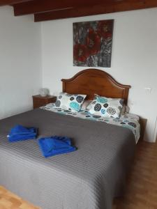 a bed in a bedroom with blue sheets and pillows at Casita De Gato in Tahiche