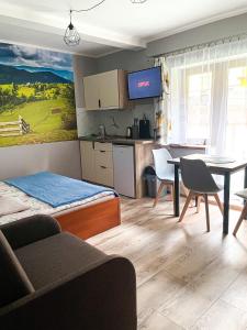 a living room with a kitchen and a dining room at Pokoje Beata in Wisła