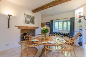 a dining room with a table and chairs and a fireplace at The Barracks in Northleach