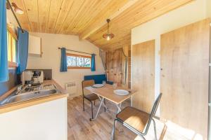 a small kitchen with a table and a sink at Camping du Lac de Saujon in Saujon