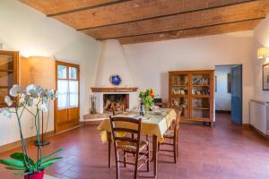 uma sala de jantar com uma mesa e uma lareira em Villa Agriturismo Tenuta la Campana em Asciano