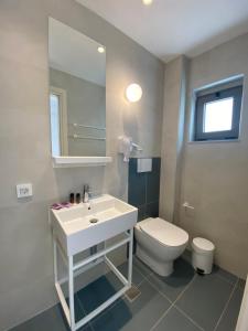 a bathroom with a white sink and a toilet at Frini Hotel in Chania Town