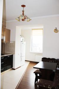 a white kitchen with a table and a refrigerator at Центр міста однокімнатна новобудова in Lutsk