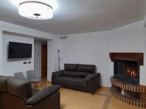 sala de estar con sofá y chimenea en Alojamientos Rurales Villora, en Murcia