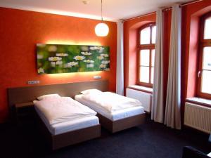 two beds in a room with two windows at Stary Młyn in Strzelce Opolskie