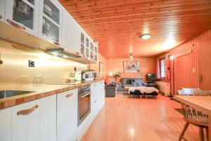 a kitchen with a table and a living room at Chalet Castellani Apartment in Fiesch