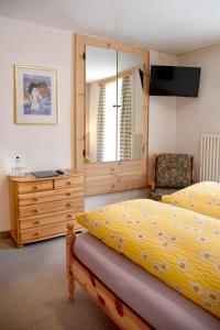 a bedroom with two beds and a dresser at Albergo Lardi in Le Prese, Poschiavo