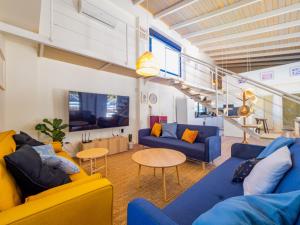 salon z niebiesko-żółtymi meblami i schodami w obiekcie Cubo's Villa Loft El Parador de la Sierra w mieście Alhaurín el Grande